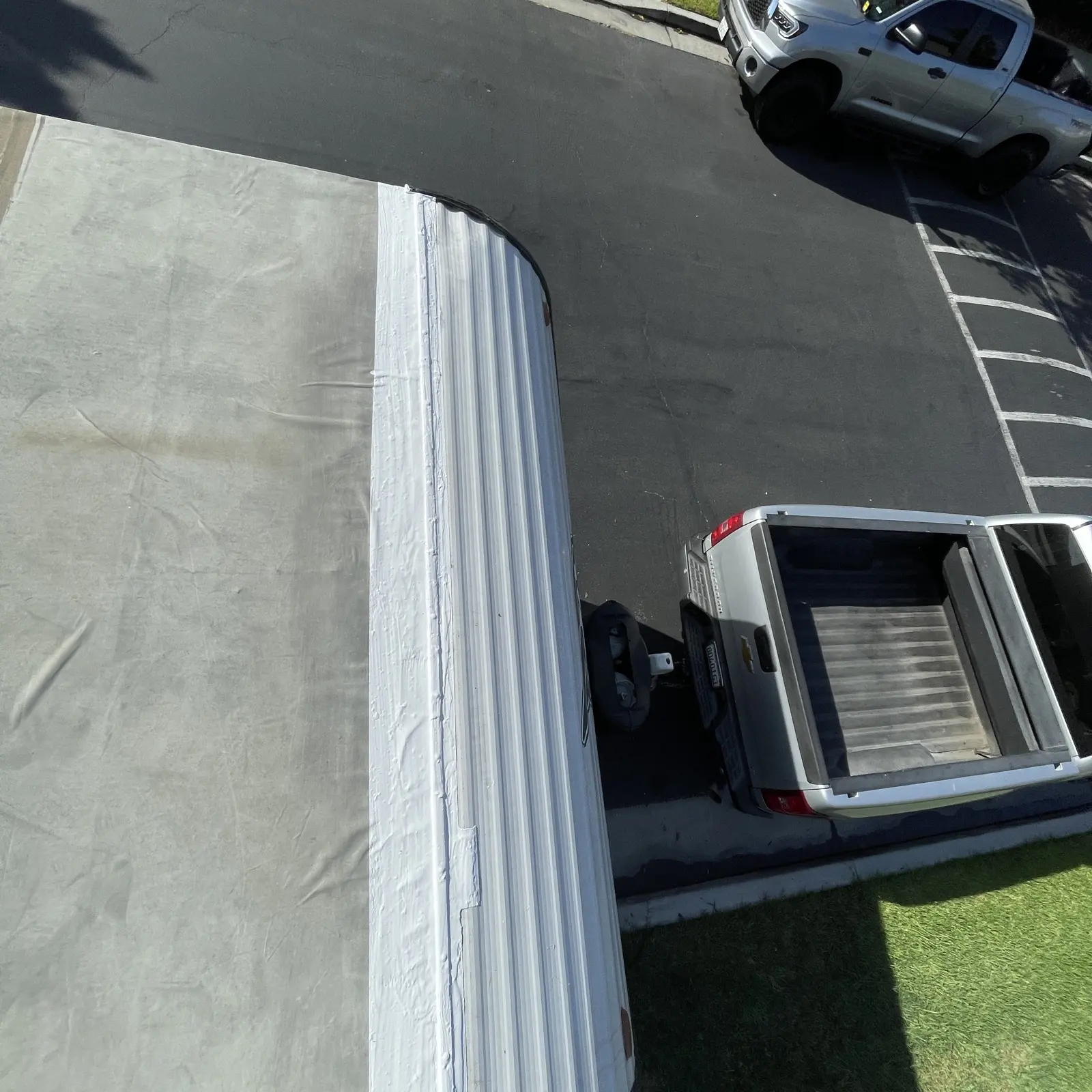 Travel trailer roof after membrane repair on a residential street in Orange County, crew truck at the curb