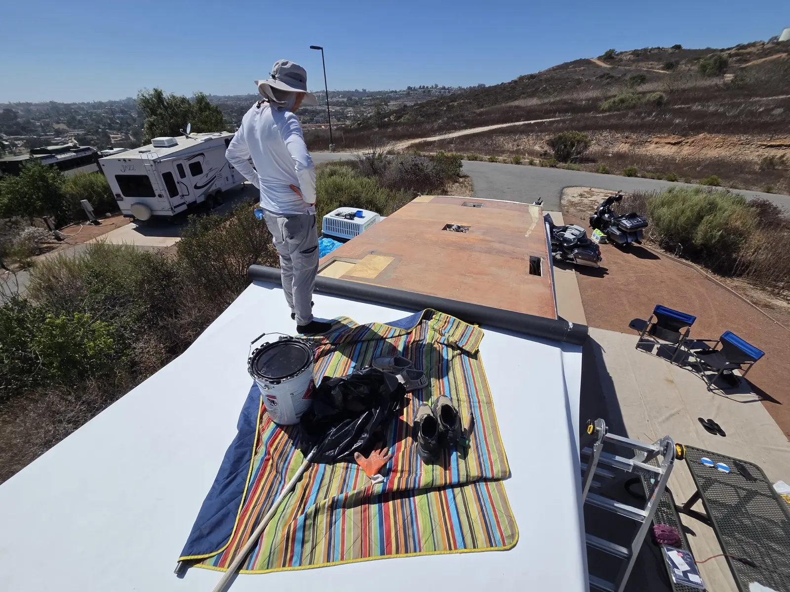 Rolling new TPO onto the deck with adhesive on the roof
